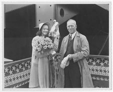 Woman holding flowers, and man holding his hat, aboard the towboat "Stanolind A"