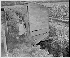 Girl next to outhouse