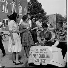 Student gather around golf cart