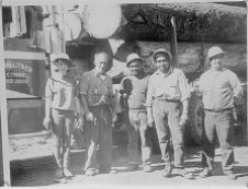 Group of people next to logging truck 