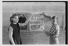 Children with ‘American Education Week' poster 