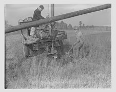 Men drilling and putting up electricity poles 