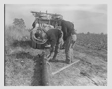 Men drilling and putting up electricity poles 