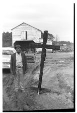 African American man standing next to a cross