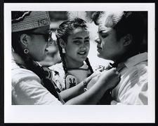 Three women in traditional regalia attending a powwow