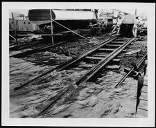 Boat on railroad tracks leading into water.
