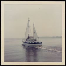 Sailboat moving at low speed.  Stern portside view