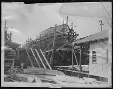 Barbour Boat Works, building a ship in New Bern, NC. Starboard view of BARS 5. Photo attatched to glass, that is broken on upper right corner.