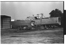 Osprey:  Portside view of boat on land coming out of warehouse.