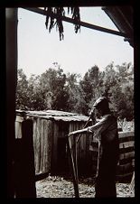 Man splitting a pole. Black and white photo. 