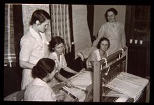 Group of women at a loom. Black and white photo. 