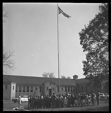 Students and teachers facing the U.S. Flag