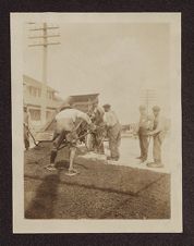 Dump truck and men grading a road