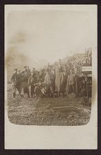 Uniformed soldiers standing next to railway cars