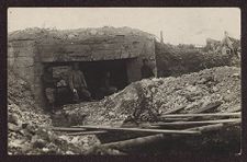 Five uniformed soldiers standing near a hollowed-out stone structure