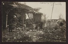 Uniformed soldier in front of a partially destroyed building