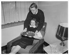 A woman is presented with a Valentine from the man behind her