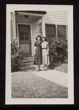 Two women in front of house