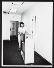 Staff pushing cart of library books