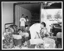 Workers unloading chairs from a truck docked outside of Joyner Library