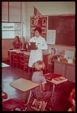 Public health dental hygienist teaching a class of school children