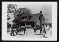 Ponies and children in front of house