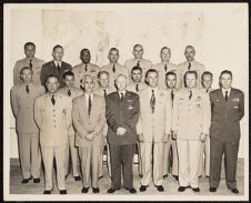 Photograph of men in military uniforms and and civilian clothes posing