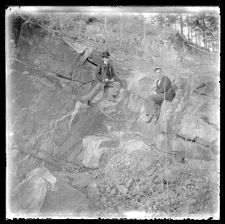 Two men sitting on huge rocks on a hillside