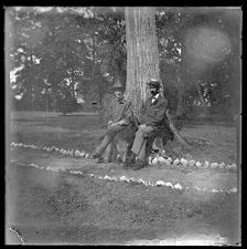 Two men named W. N. Old and N. Penick resting against a tree on the grounds of Bayside Plantation, Pasquotank County, North Carolina