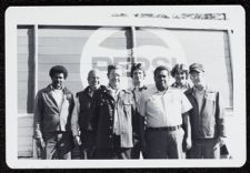 Pepsi sign, seven men standing in front