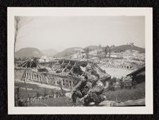 Destruction around Hitler's home in Bavarian mountains with two US Army soldiers kneeling in the picture.